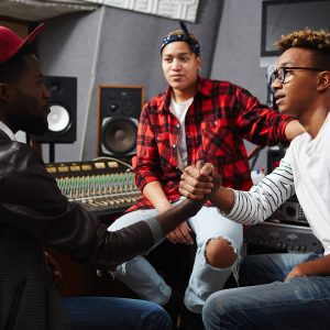 Músicos dándose la mano en un estudio de producción